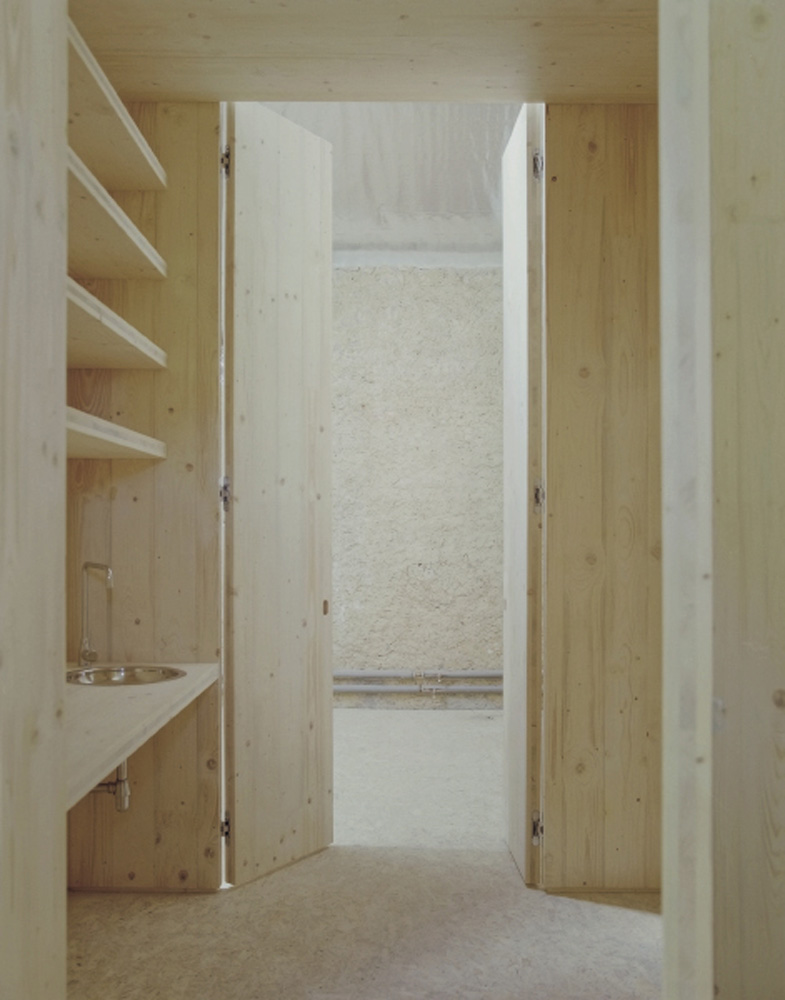 HAGHAB: a wooden module integrates kitchen, sleeping area, and bathroom, blending domestic climatic comfort into the barn.